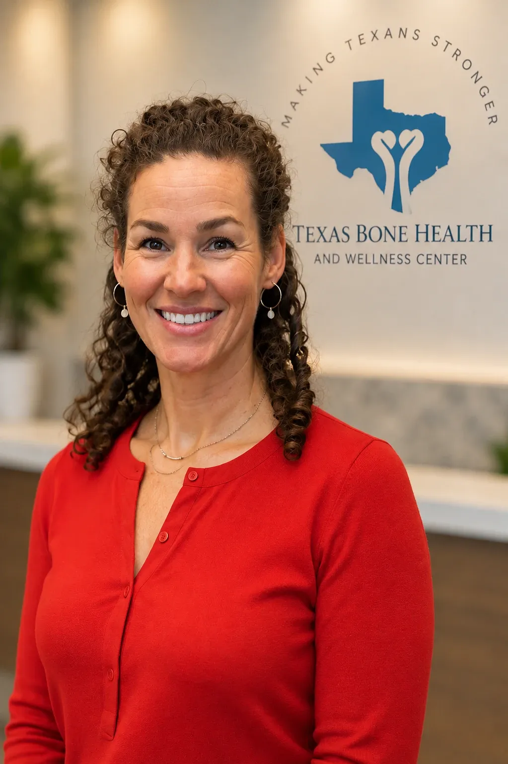 Whitney Baker, NP, smiling in front of the Texas Bone Health and Wellness Center sign